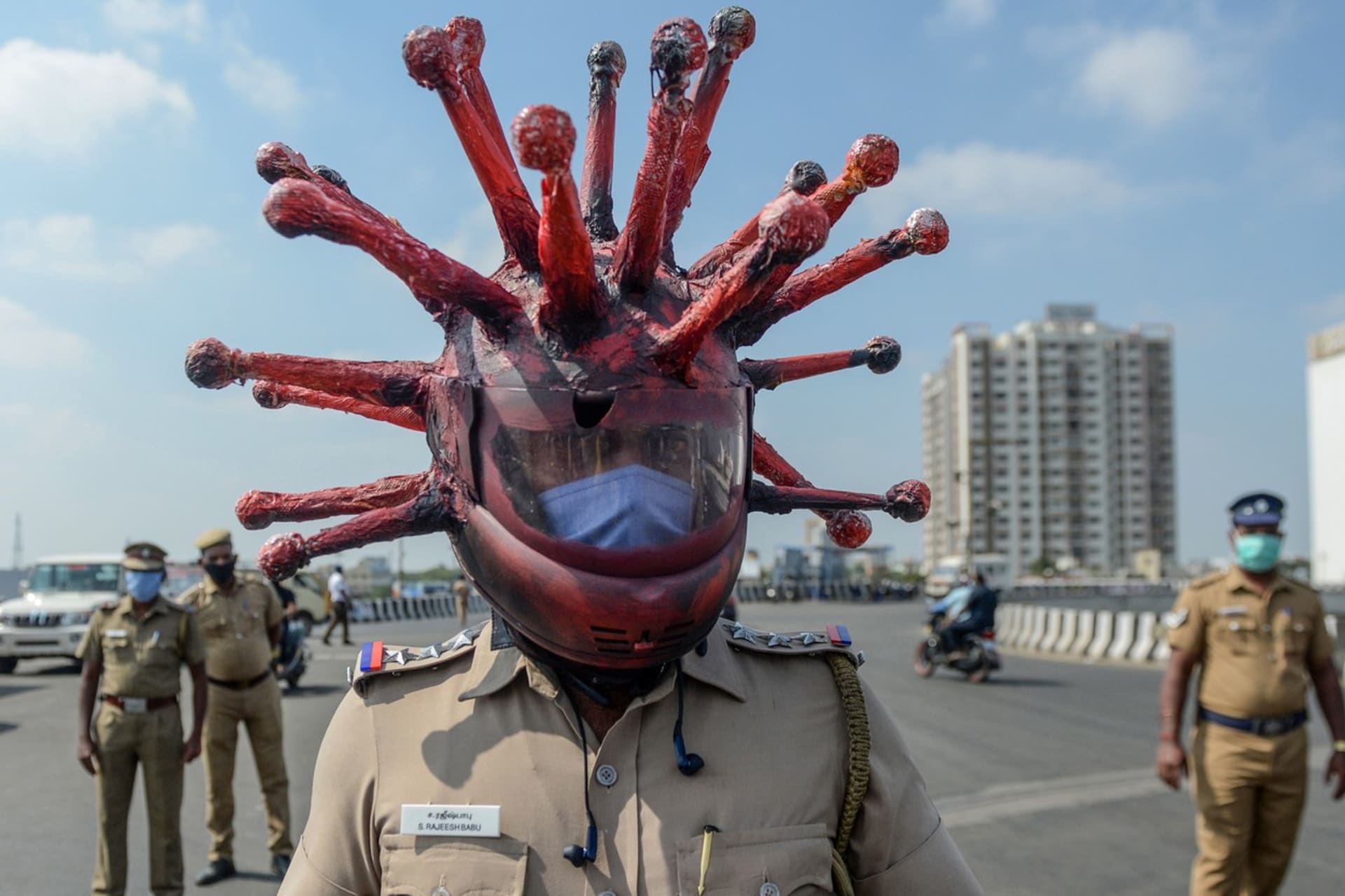 Policista s originální přilbou kontroluje dodržování karantény v indickém městě Čennaí (Profimedia.cz)