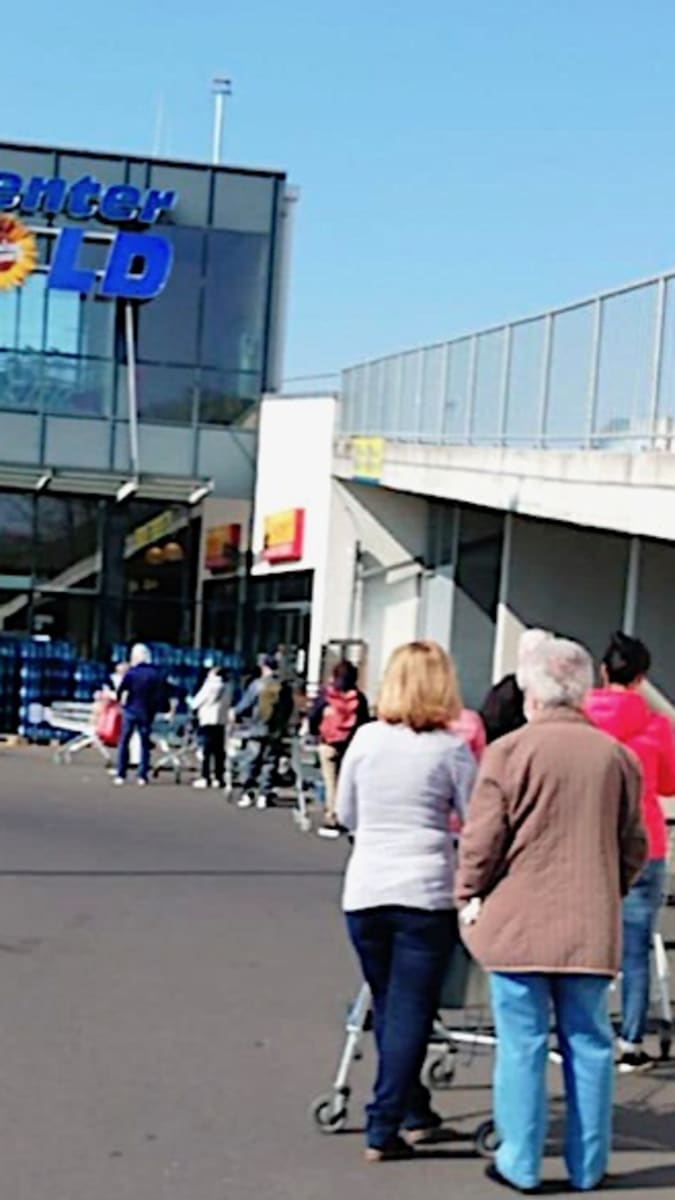 Nákup v německém Würzburgu. Lidé spořádaně čekají před obchodem.
