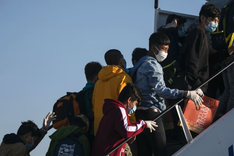 Nezletilí uprchlíci z táborů pro migranty v Řecku nastupují do letadla