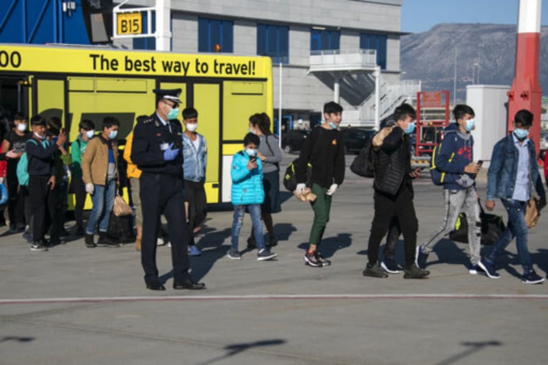 Nezletilí uprchlíci z táborů pro migranty v Řecku vystupují z letištního autobusu