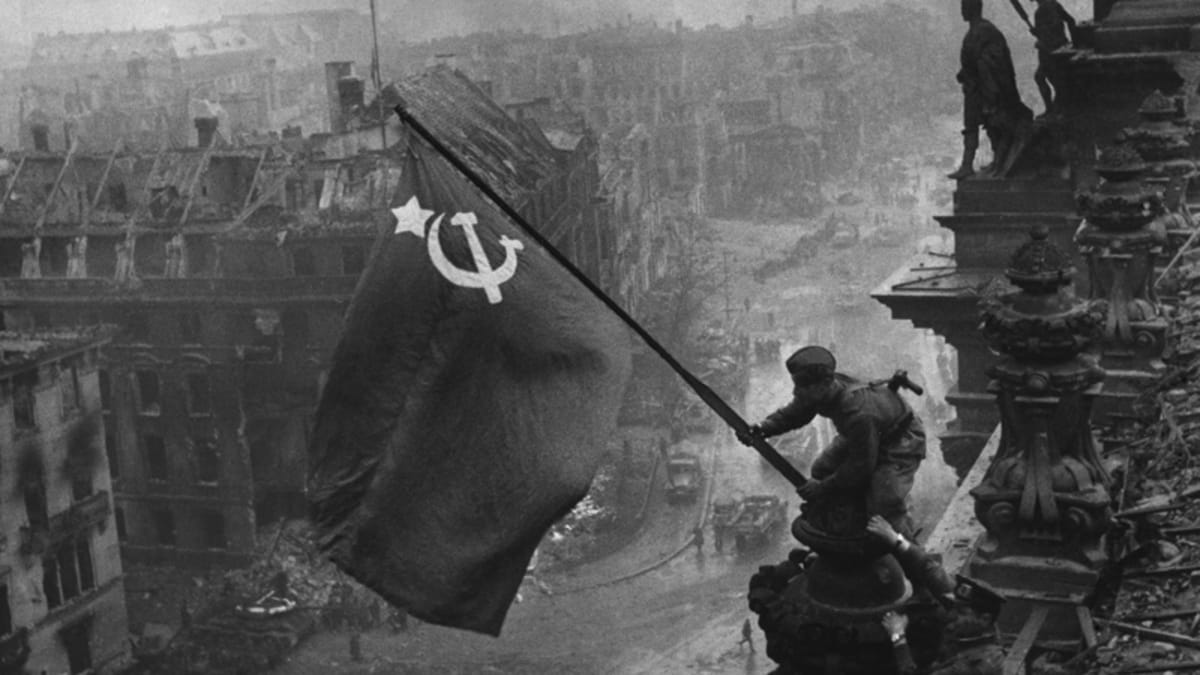 Sovětští vojáci vztyčují vlajku vítězství nad budovou Říšského sněmu v Berlíně. Válečný fotograf Jevgenij Anaňjevič Chalděj snímek aranžoval - vlajku původně vztyčil vojín Michail Minin 30. dubna 1945 ve 22:40, kdy už ovšem byla tma