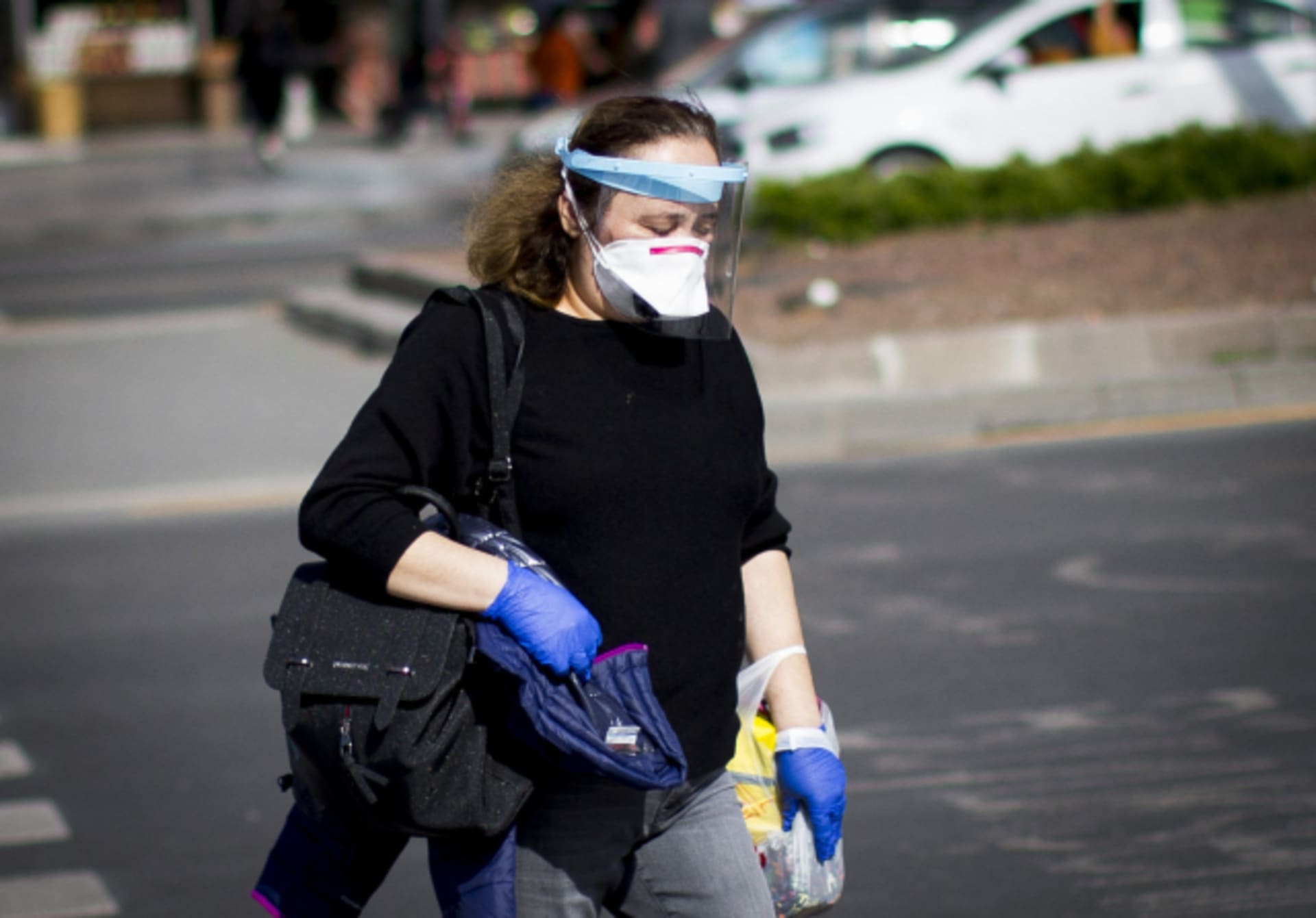 Žena se proti nákaze koronavirem chrání rouškou a obličejovým štítem.