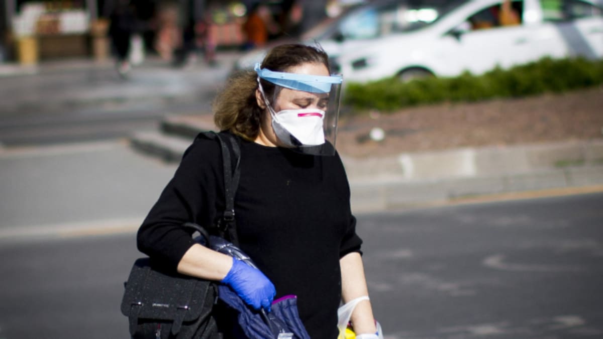Žena se proti nákaze koronavirem chrání rouškou a obličejovým štítem.