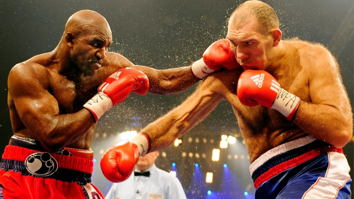 Evander Holyfield boxuje s Rusem Nikolajem Valujevem (vpravo) o titul mistra světa organizace WBA v prosinci 2008.