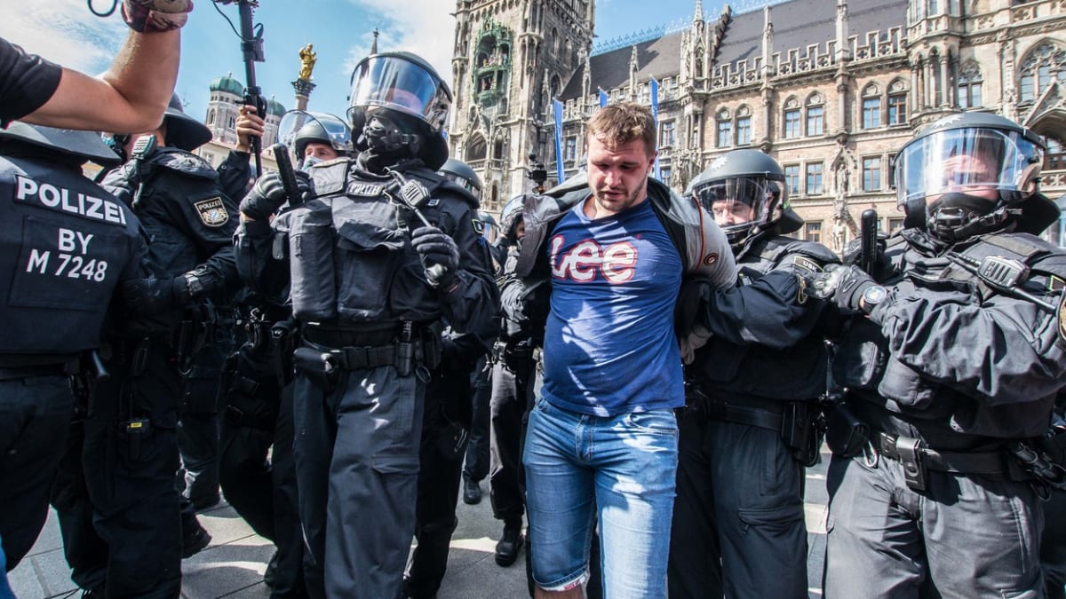 Polisticté odvádějí v německém Mnichově zadrženého muže při demonstraci proti opatřením při pandemii koronaviru. Stále častěji se stávají terčem útoků také novináři.