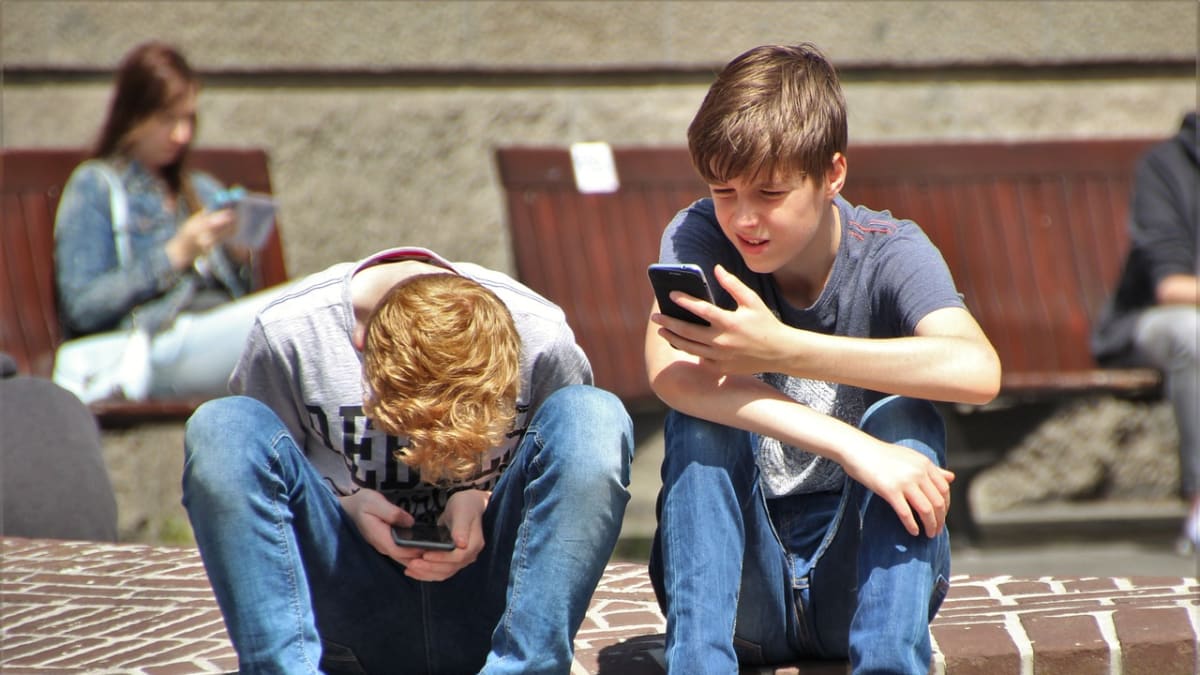 Děti hrající si na mobilech