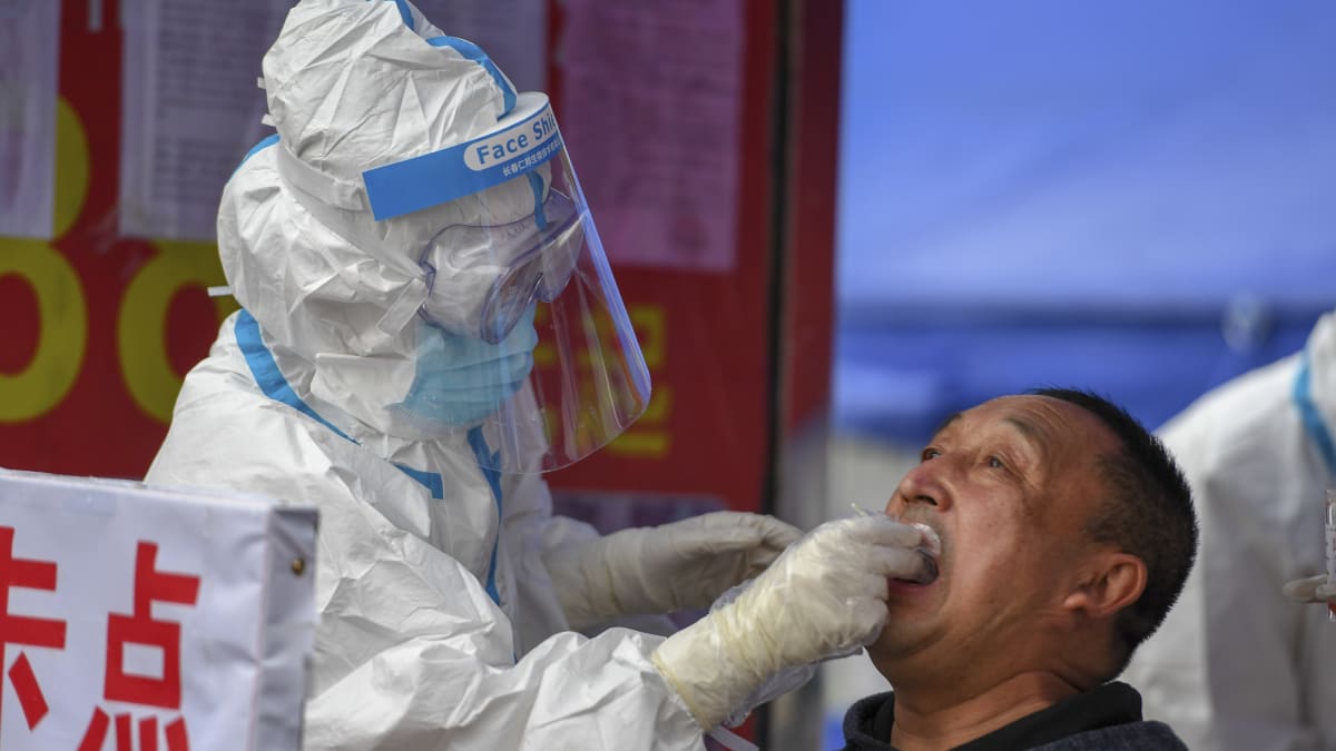Lékař v čínském městě Šu-lan provádí test pacientovi s podezřením na koronavirus