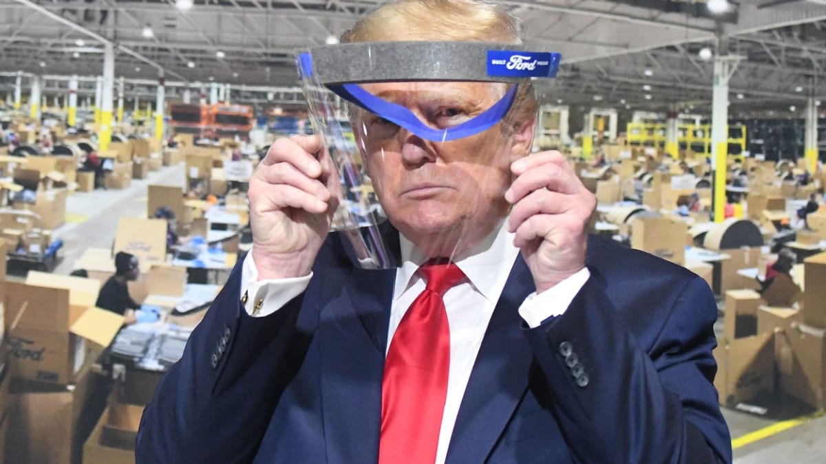 Americký prezident Donald Trump se „chrání“ štítem při návštěvě továrny Ford v Michiganu