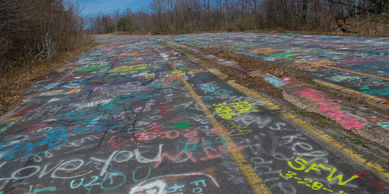 Popraskané silnice se staly atrakcí pro turisty, kteří je pokreslili graffiti malbami.
