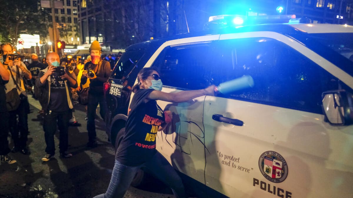 Demonstrant napadá policejní auto v Minneapolis