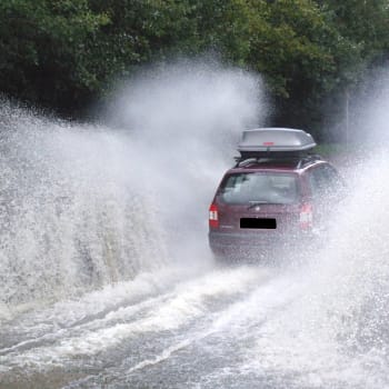 Auto v hluboké vodě na silnici po přívalovém dešti