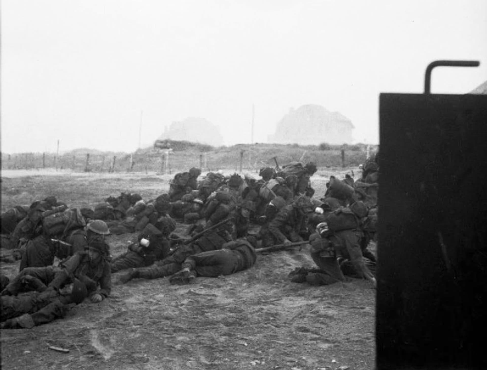Britští vojáci se kryjí před dalším postupem po vylodění na pláži Sword