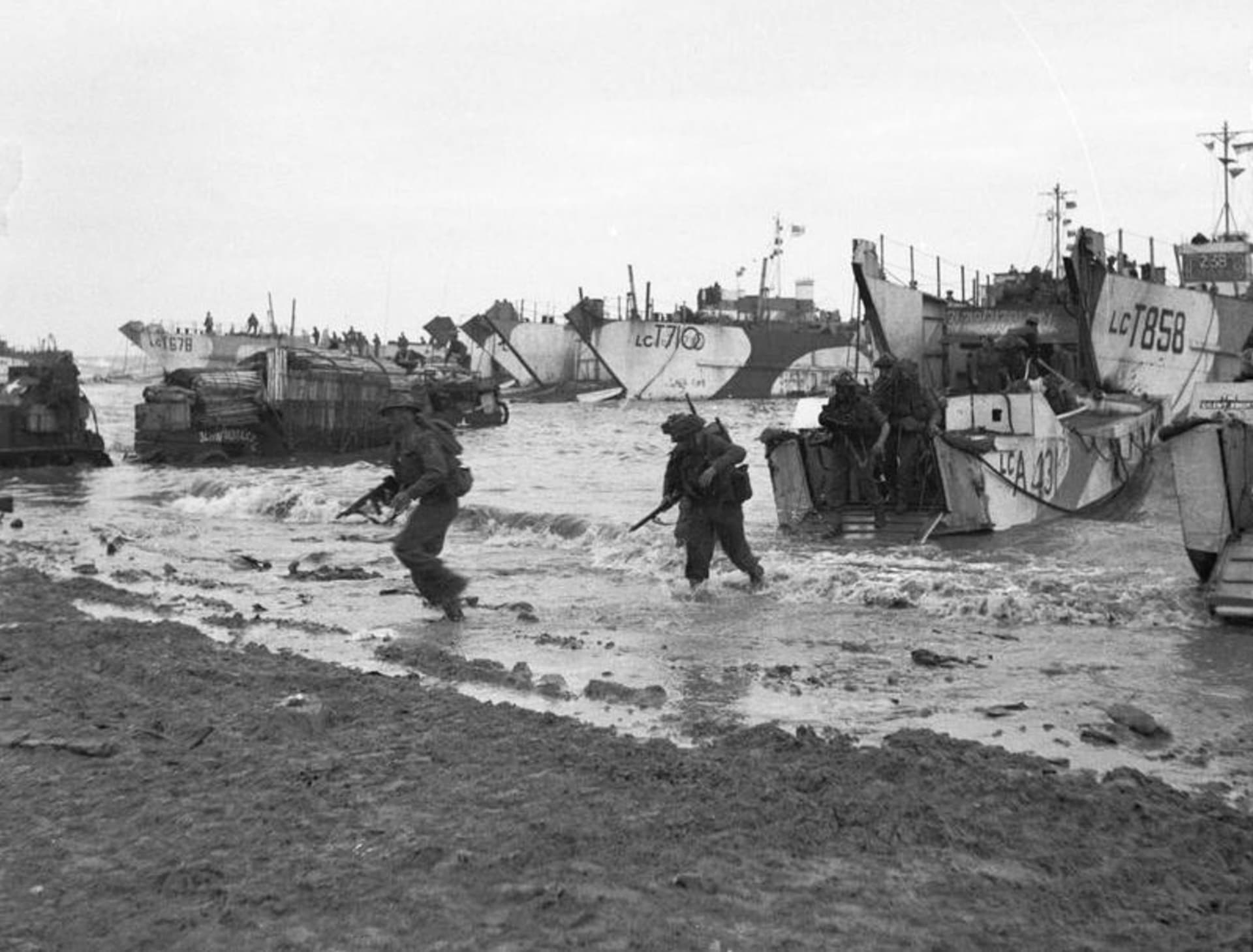 Britští Commandos se 6. června 1944 vyloďují na pláži Gold. velké vyloďovací lodě v pozadí přivezly nákladní auta a další techniku pro 231. brigádu 53. divize