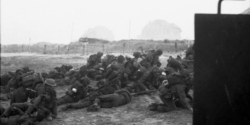 Britští vojáci se kryjí před dalším postupem po vylodění na pláži Sword