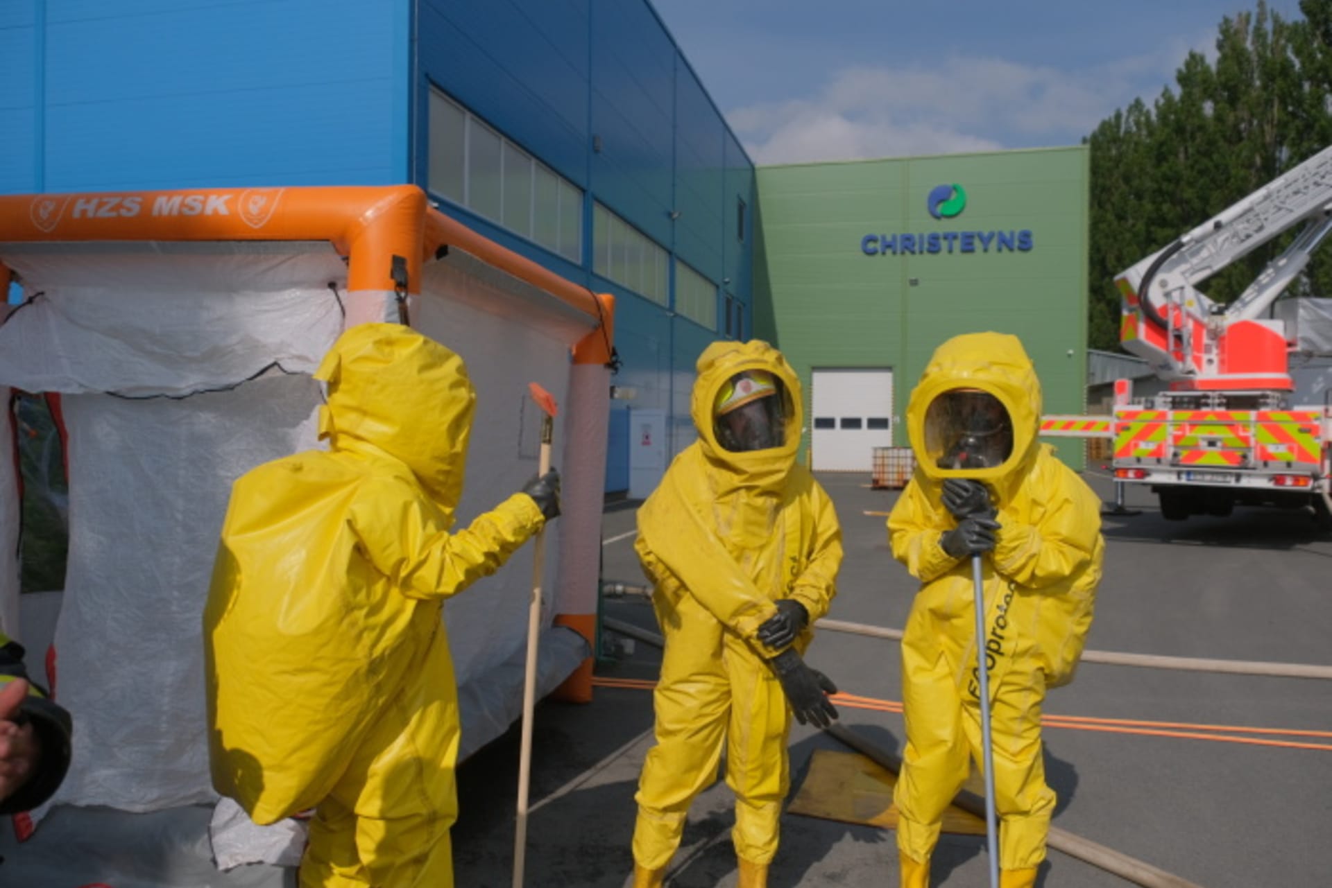 Hasiči vyvezli v protichemických oblecích z tovární haly kontejner s chemickými látkami.