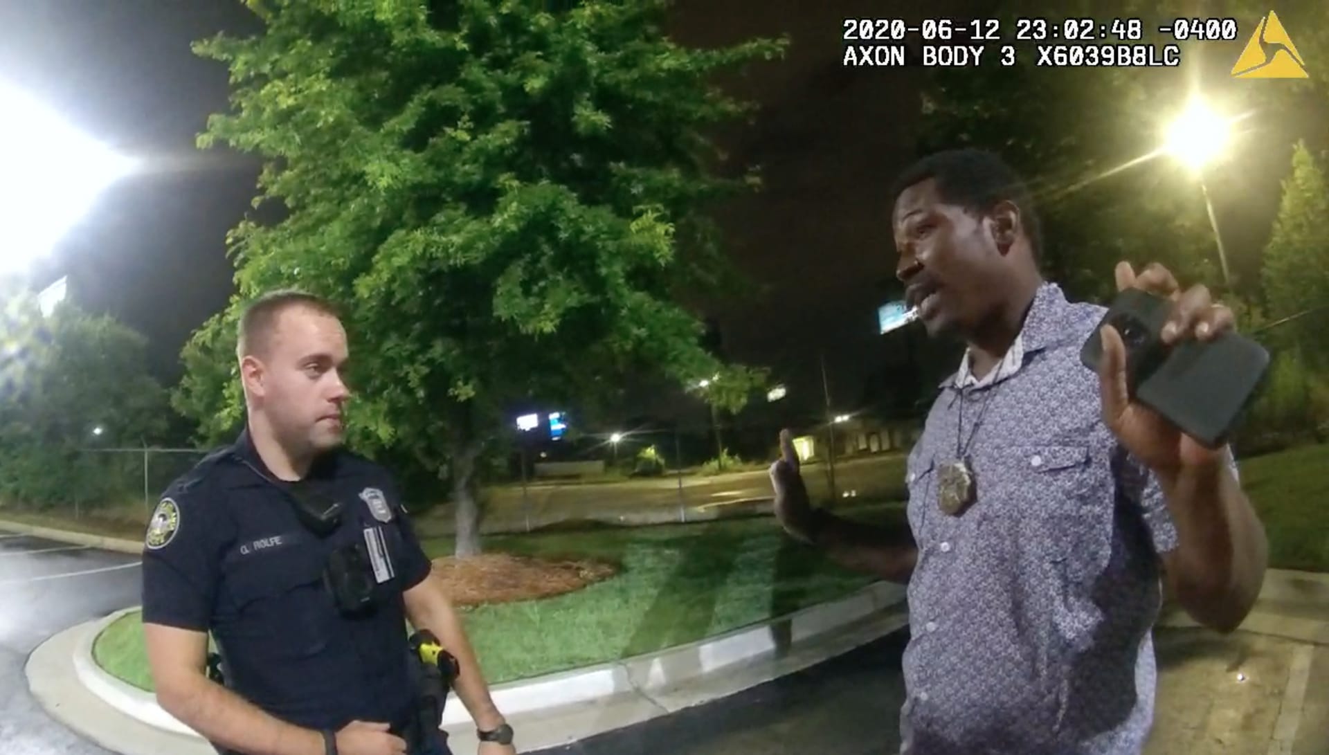 Na snímku pořízeném 12. června v Atlantě je vidět policista Garrett Rolfe (vlevo), který hovoří s Rayshardem Brooksem. O chvíli později ho střelil dvakrát do zad.  
