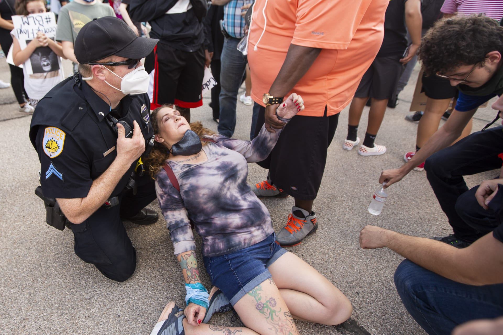 Policista E.J. Stewart zasahuje při protestech v americkém městě Odessa v Texasu, pomáhá ženě, která se zhroutila.
