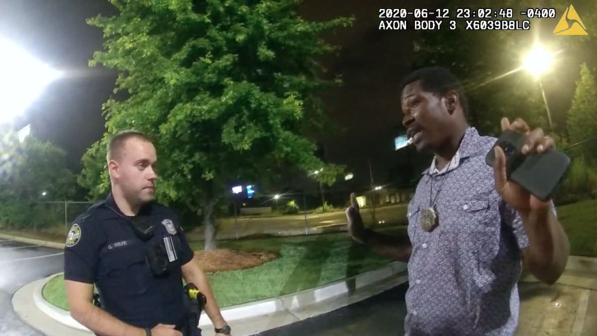 Na snímku pořízeném 12. června v Atlantě je vidět policista Garrett Rolfe (vlevo), který hovoří s Rayshardem Brooksem. O chvíli později ho střelil dvakrát do zad.  