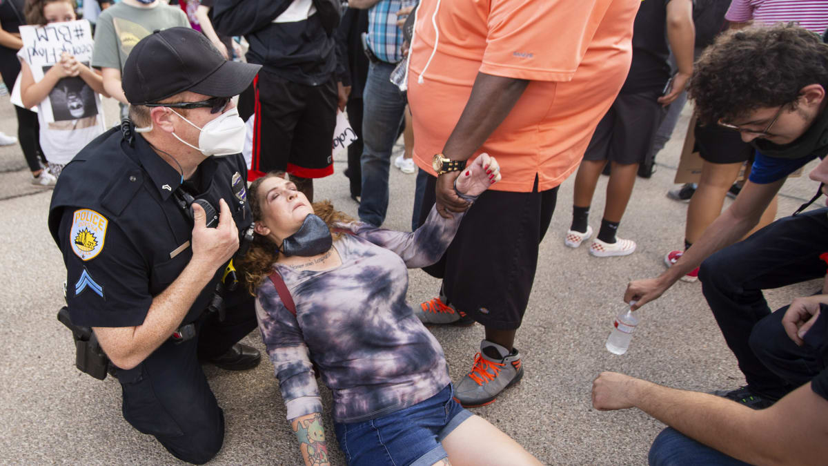 Policista E.J. Stewart zasahuje při protestech v americkém městě Odessa v Texasu, pomáhá ženě, která se zhroutila.