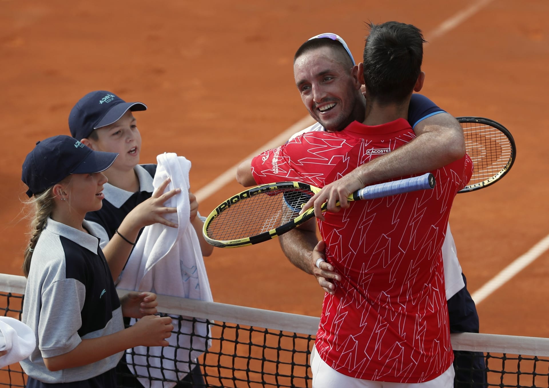 Novak Djokovič se objímá s dalším srbským tenistou Viktorem Troickim po exhibičním utkání v Bělehradě.