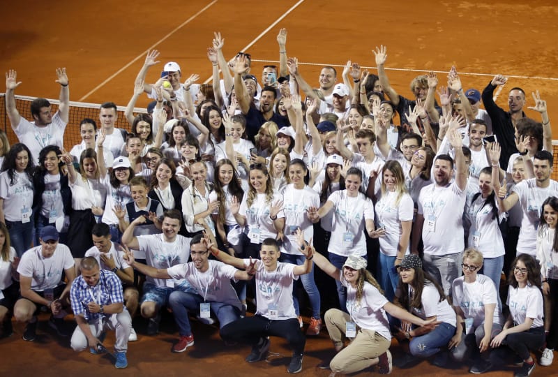 Novak Djokovič (uprostřed v černém) mává s dobrovolníky po skončení prvního turnaje série Adria Tour.