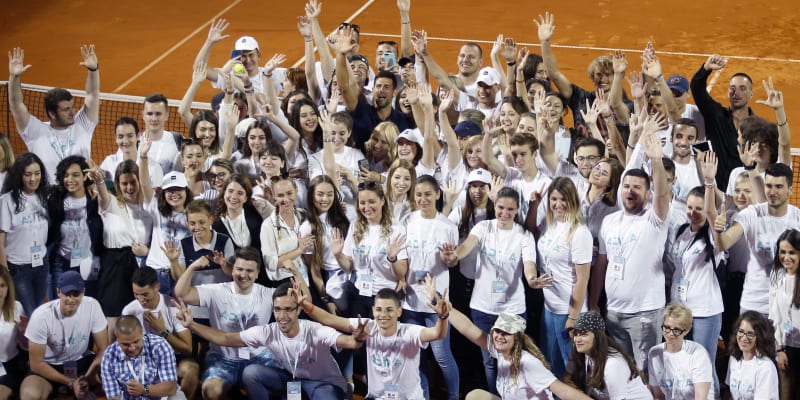Novak Djokovič (uprostřed v černém) mává s dobrovolníky po skončení prvního turnaje série Adria Tour.