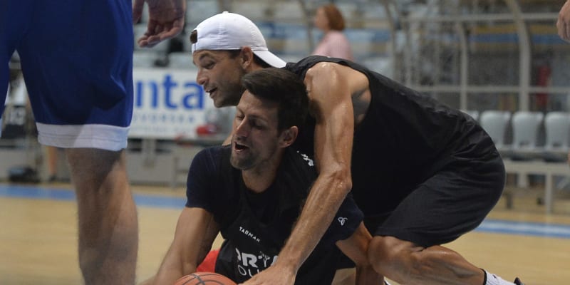 Bulharský tenista Grigor Dimitrov brání Novaka Djokoviče (na zemi) při basketbalovém klání v Bělehradě v rámci exhibic Adria Tour.