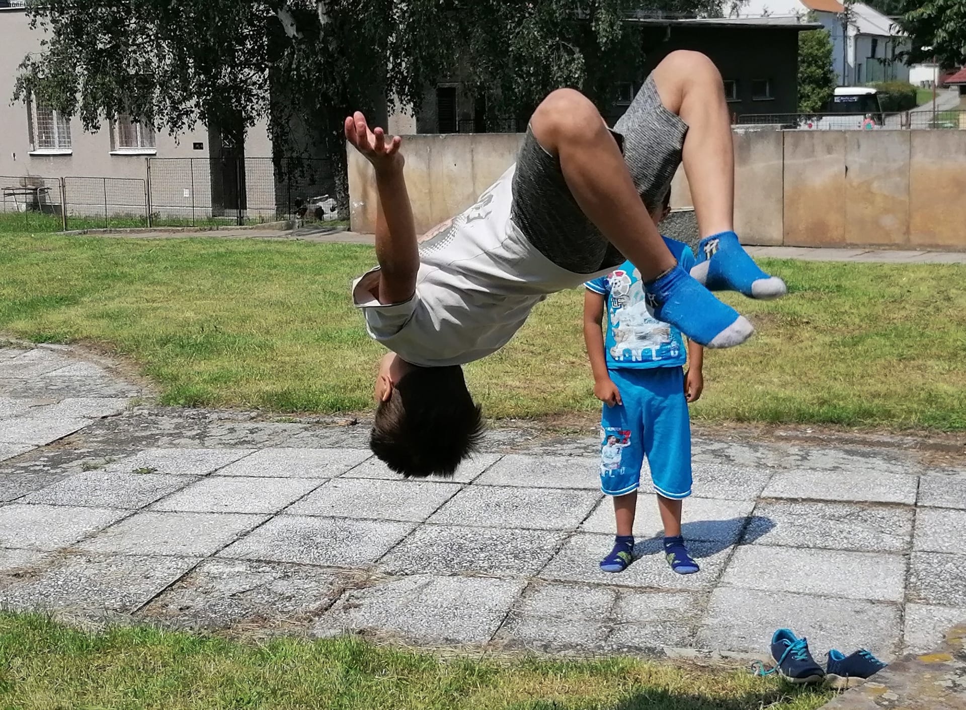 Děti trénují přemety na betonových podstavcích pomníku Osvobození.