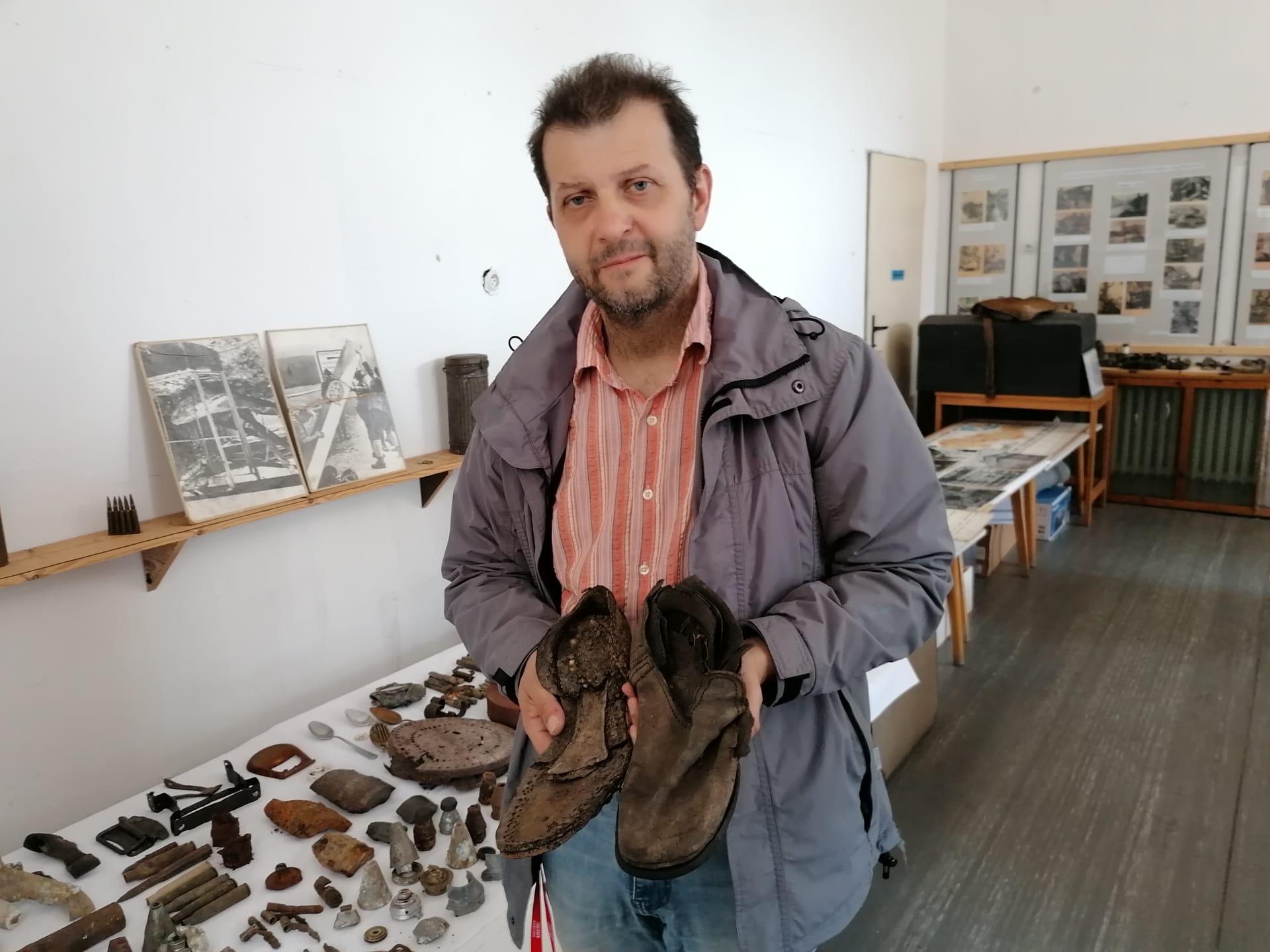 Marian Hrabovský, zastupitel obce, učitel spoluzakladatel osoblažského muzea drží v ruce zbytky bot rudoarmějce z roku 1945.