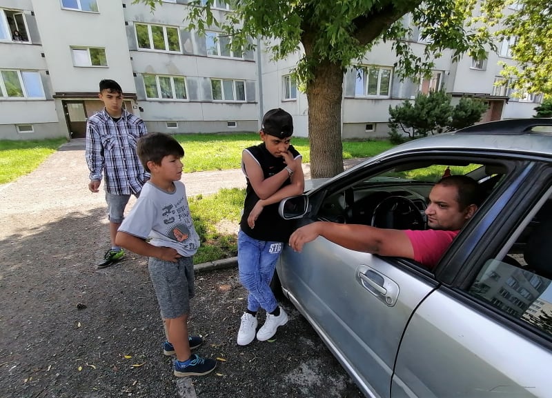 Pan Gustav s dětmi před bytovkami v Osoblaze. 
