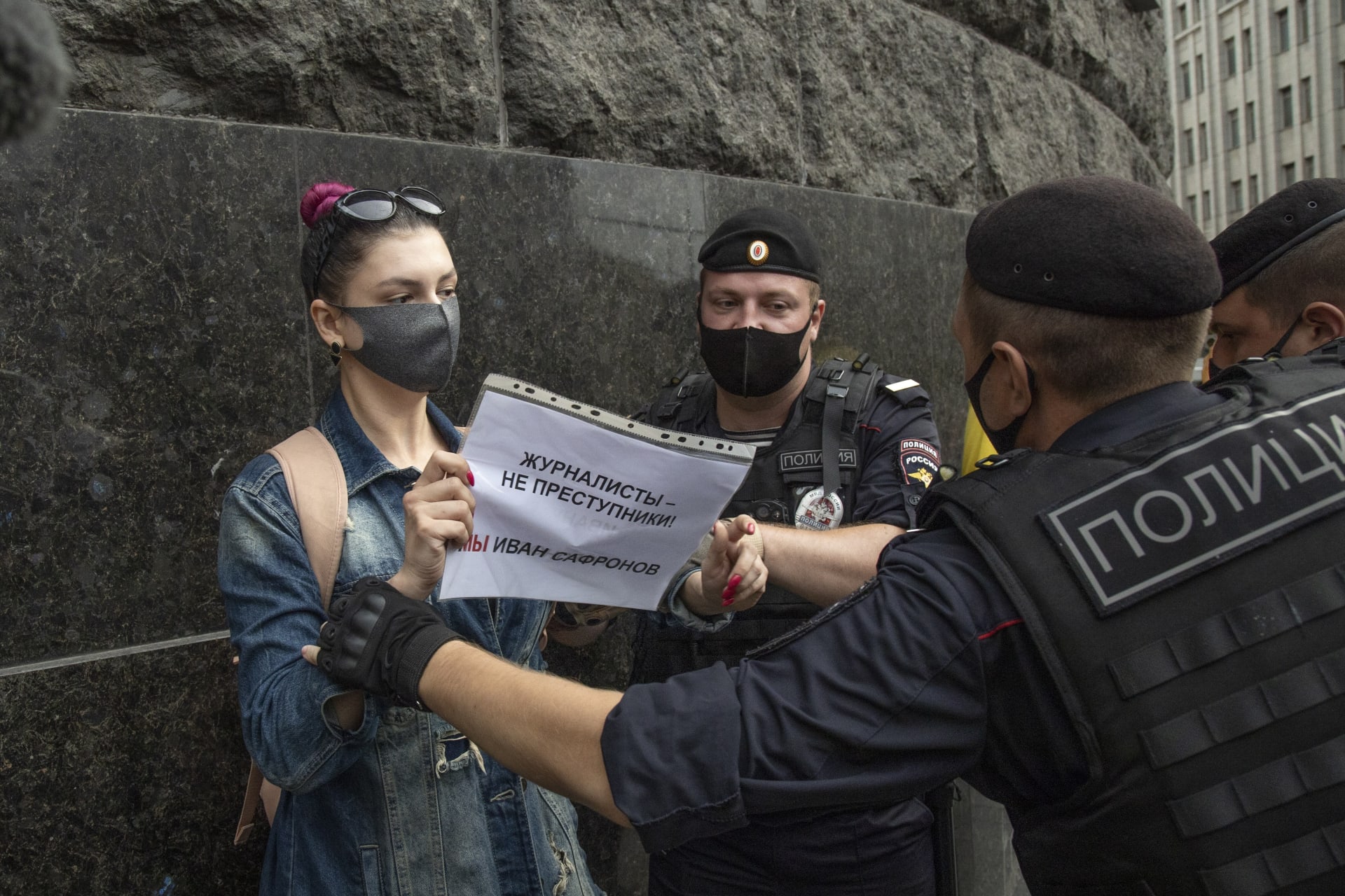 Ruská novinářka Maria Šersťjukovová se brání policistům při protestní akci v Moskvě den po zadržení Ivana Safronova, poradce šéfa agentury Roskosmos. V rukách má transparent s nápisem Novináři nejsou zločinci, my jsme Ivan Safronov.