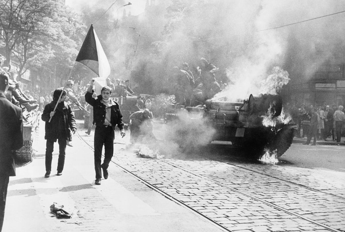 Pražané s vlajkou, v pozadí hořící invazní tank