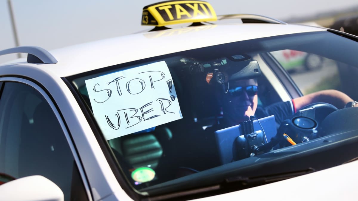 Řidič taxi protestuje v Brně proti službě Uber, kterou úředníci nakonec ve městě skutečně zakázali. Nyní se po změně zákona situace mění a Uber může od konce července v Brně opět jezdit.