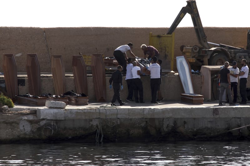 Pracovníci pohřební služby na italském ostrově Lampedusa manipulují s rakvemi, do kterých v přístavu ukládají těla mrtvých migrantů.