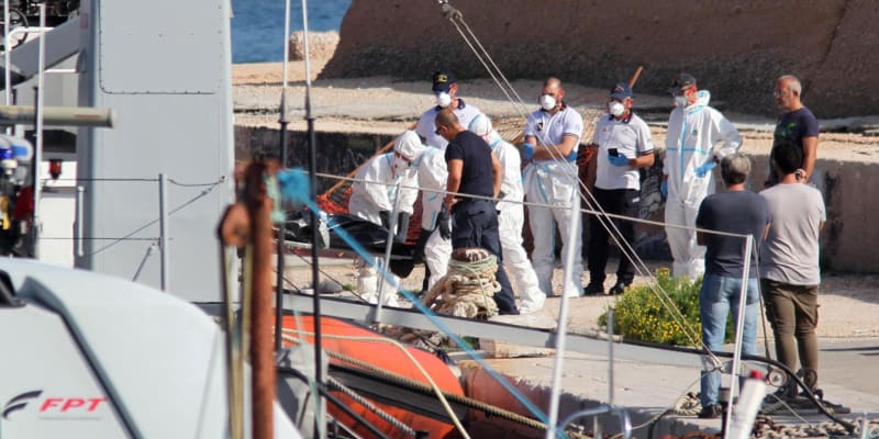 Zdravotníci kontrolují muže v italském přístavu Lampedusa.