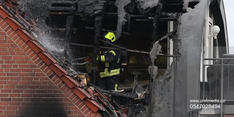 Hasič dohašuje střechu domu v německém městě Wesel, na kterou spadlo malé ultralehké letadlo.