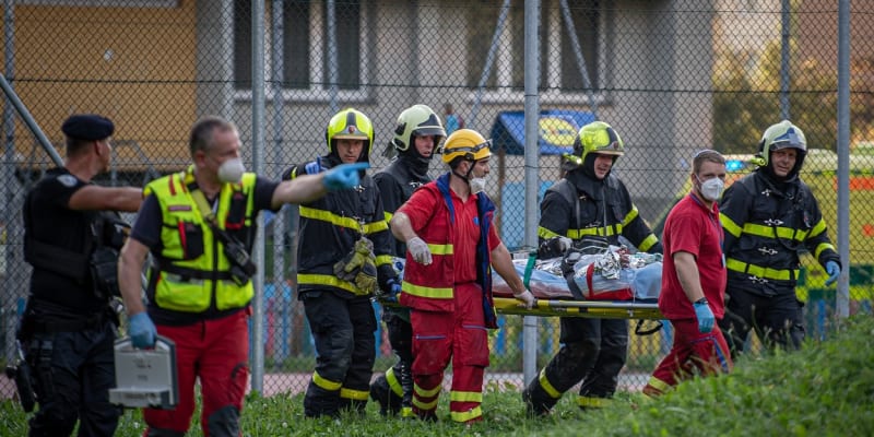 Hasiči odnášejí jednu z obětí sobotního požáru v Bohumíně