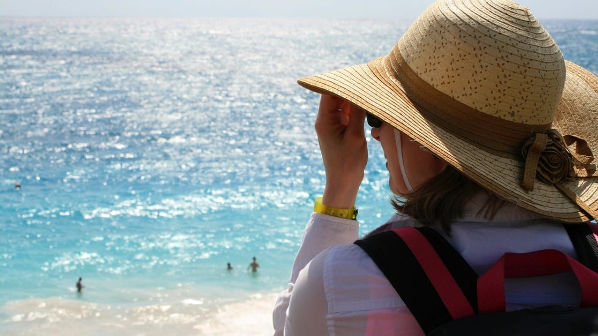 Žena v klobouku u pláže