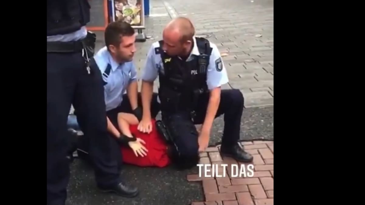 Německý policista zaklekává podezřelého