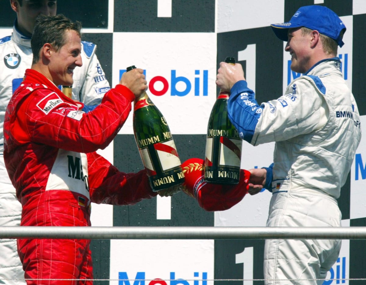 Tak na zdraví, brácho. Michael a Ralf (vpravo) Schumacherové se radují na stupních vítězů při domácí Velké ceně Německa na Hockenheimringu 28. července 2002. 