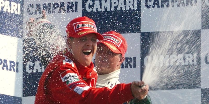 Sprcha šampaňským. Třetí ve Velké ceně Itálie v Monze 10. září 2000 Ralf Schumacher (vzadu) sprchuje šampaňským svého vítězného bratra Michaela.
