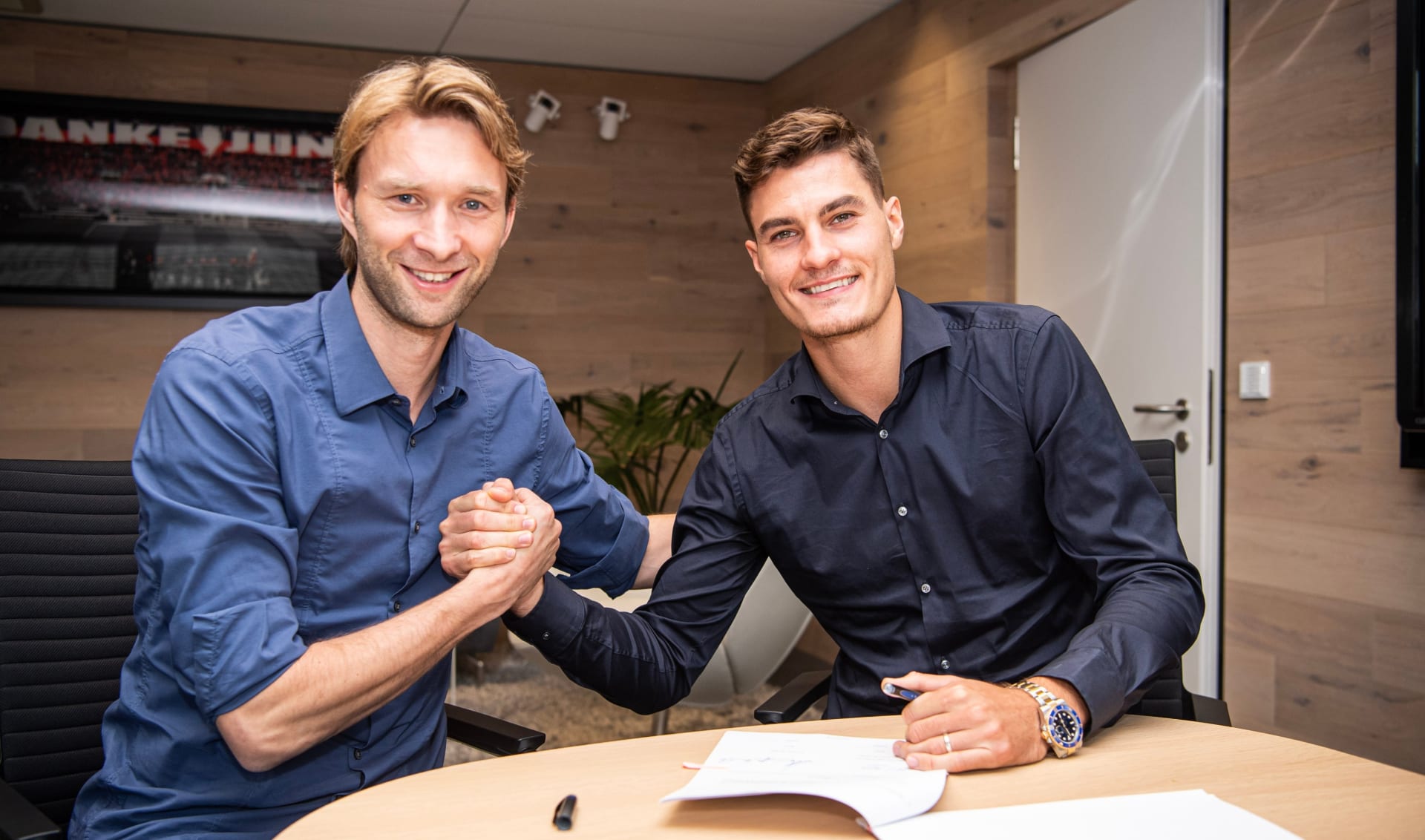 Fotbalový útočník Patrik Schick (vpravo) přijímá gratulace od sportovního ředitele Simona Rolfese k podpisu pětileté smlouvy v Bayeru Leverkusen.