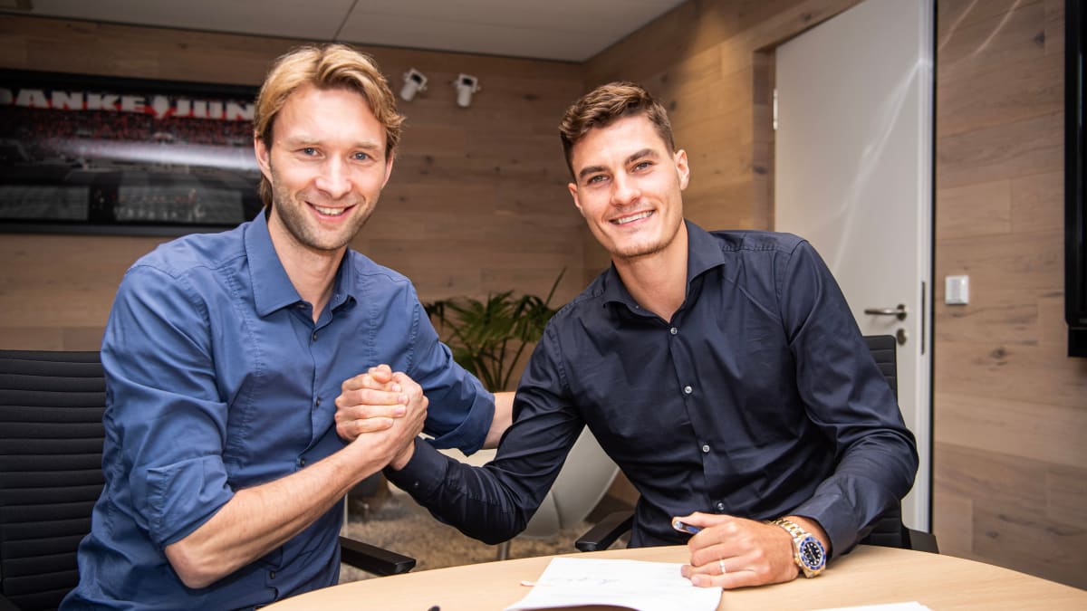 Fotbalový útočník Patrik Schick (vpravo) přijímá gratulace od sportovního ředitele Simona Rolfese k podpisu pětileté smlouvy v Bayeru Leverkusen.