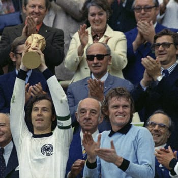 Franz Beckenbauer jako kapitán německé reprezentace drží nad hlavou trofej pro mistry světa z roku 1974. Vpravo brankář Sepp Maier.