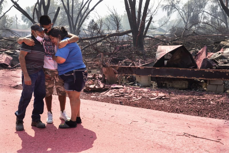  Maria Centeno (vpravo) z Mexika, pláče na rameni souseda Hectora Rocheta uprostřed místa, kde dřív stály jejich zničené mobilní domy. Městem Talent v Oregonu se prohnal pustošivý požár.