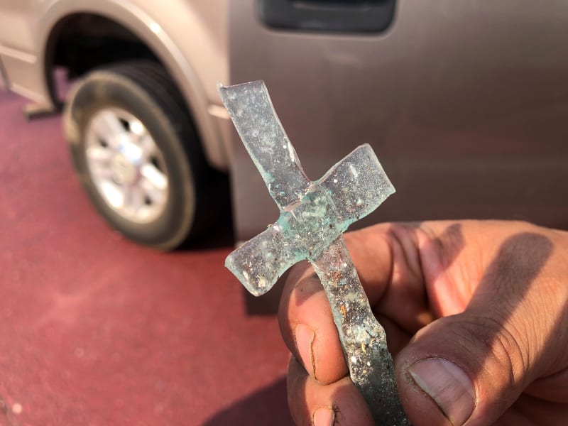 Artemio Guterrez, svobodný otec čtyř dětí, drží kříž vyrobený ze dvou kusů skla, které se během požáru roztavilo. Guterrez měl sotva čas na útěk se svými dětmi.