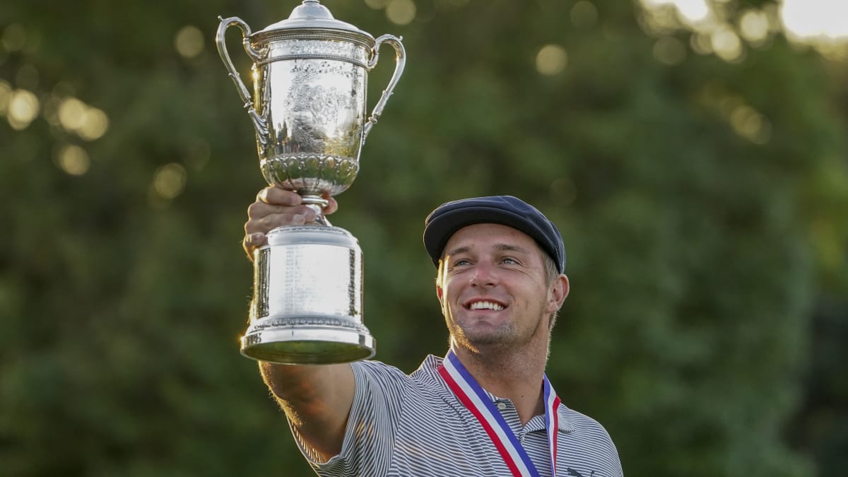 Americký golfista Bryson DeChambeau se raduje a pózuje s pohárem za vítězství na US Open v Mamaronecku.