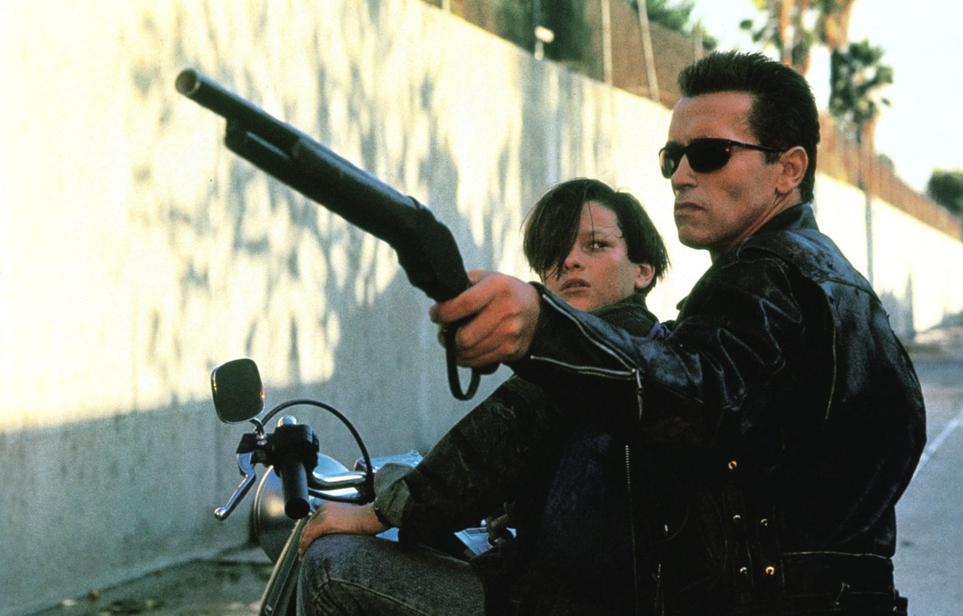 Terminátor 2: Den zúčtování. Arnold Schwarzenegger v jedné ze svých nejslavnějších rolí vůbec. Zde zachraňuje Johna Connora v podání herce Edwarda Furlonga před útokem terminátora T-1000.
