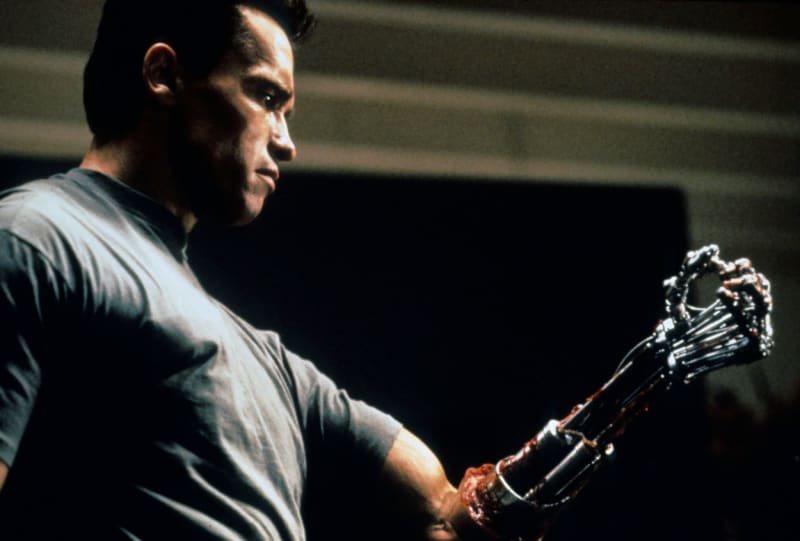 „A teď mě dobře poslouchejte." Slavná scéna z filmu Terminátor 2: Den zúčtování, v níž si Arnold Schwarzenegger coby stroj ze série T-800 „svlékl" tkáň na předloktí, aby dokázal, že skutečně není člověkem.