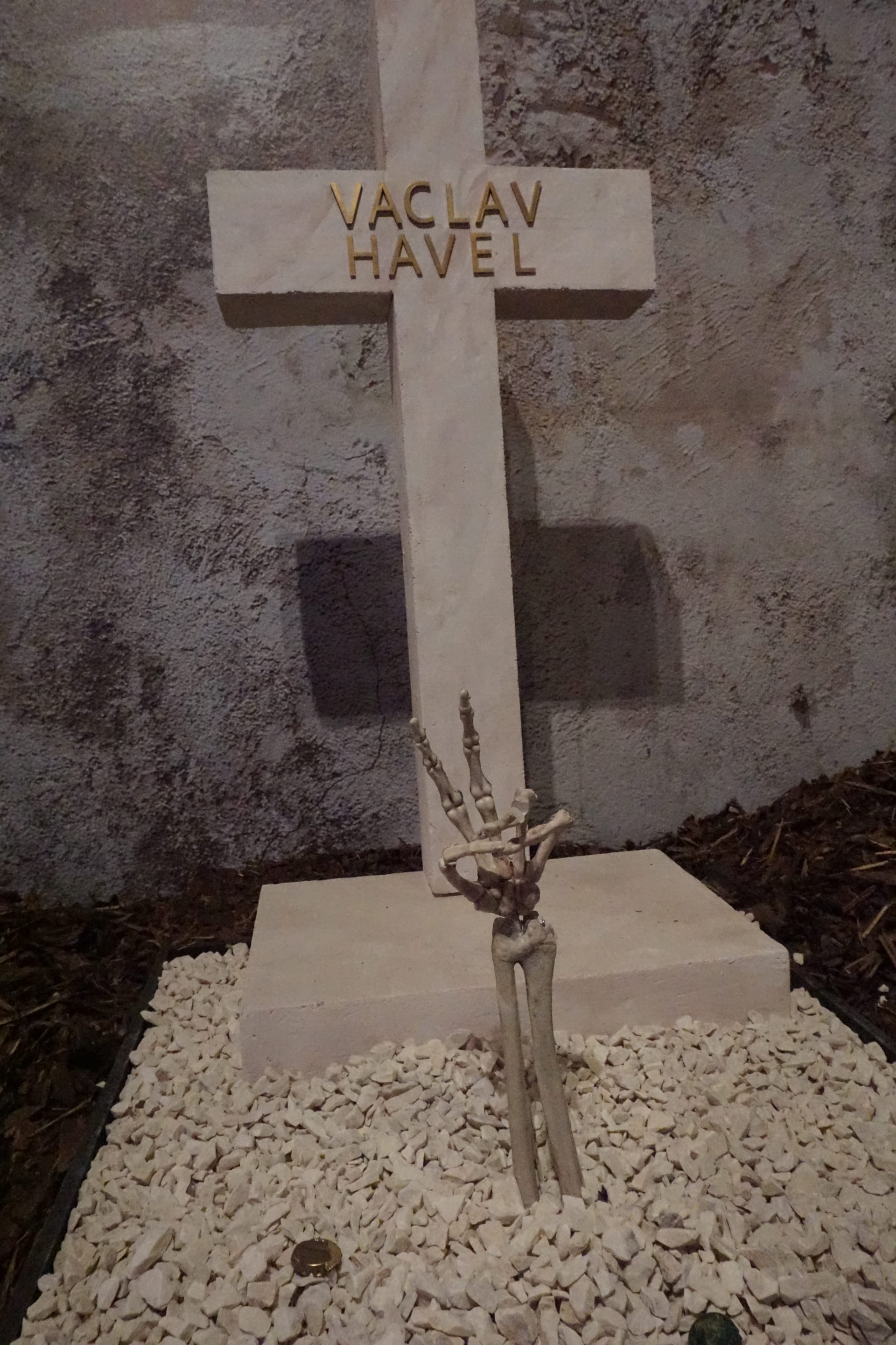 Hrob prvního prezidenta po Sametové revoluci Václava Havla vypadá zcela standardně, jako by byl na běžném hřbitově. Z něj se však tyčí do vzduchu ruka kostlivce, která návštěvníkům ukazuje Havlovo typické gesto.